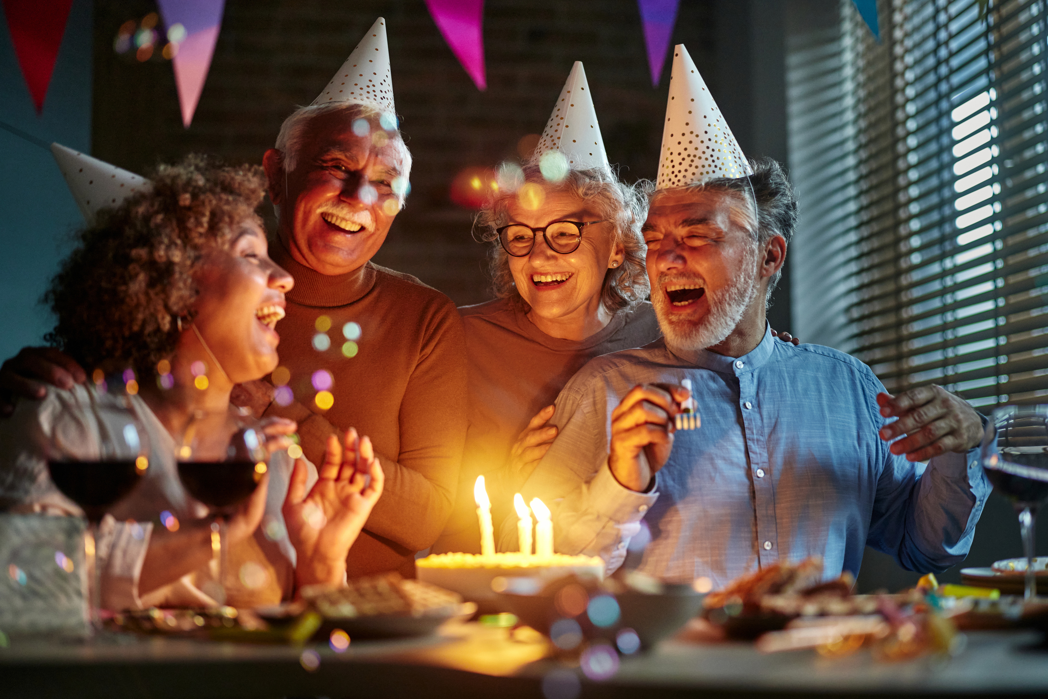 Cheerful senior friends celebrating Birthday at home.